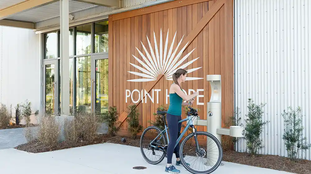 A woman in the Point Hope community stops to fill her water bottle while biking.
