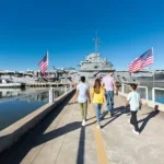 Patriots Point Naval & Maritime Museum- view of the USS Laffey (foreground, left) and the USS Yorktown (background) as a family walks toward the historic ships.