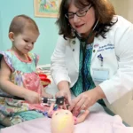 Dr. Kraveka with a young patient sharing a lighthearted moment