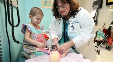 Dr. Kraveka with a young patient sharing a lighthearted moment