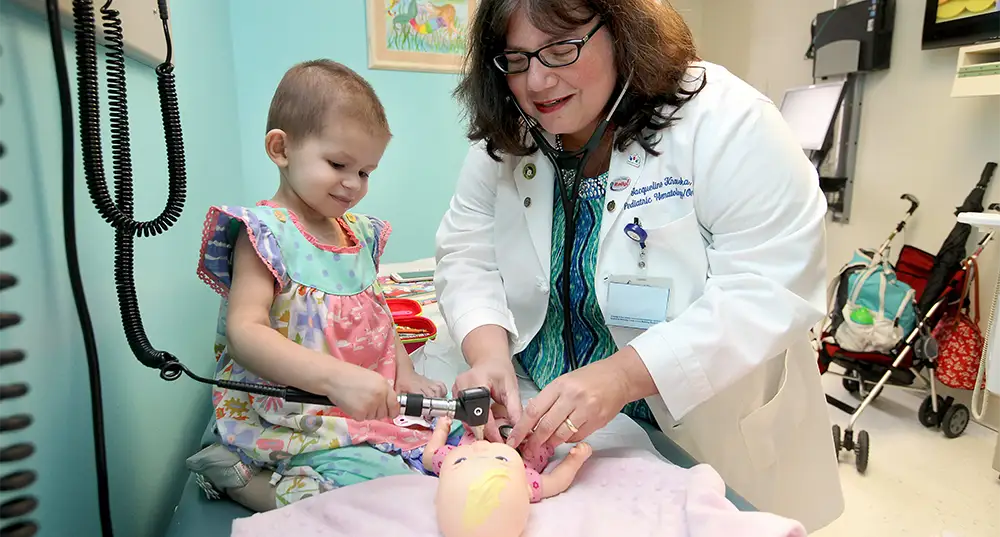 Dr. Kraveka with a young patient sharing a lighthearted moment