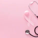 Breast Cancer Awareness graphic. A pink ribbon, stethoscope with pink ear tubes on a pink background