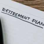Photo of a pen and a notebook labeled "Retirement Plan"