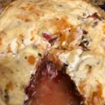 A photo of a tomato pie in its aluminum foil pie pan