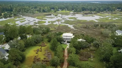 5188 Timber Race Course for sale in Hollywood, SC. Photo shows the property from the air, including the home, driveway, tree stands on the property and surrounding marsh areas.