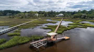 Photo of the home in the distance taken from the marsh showing the private deep-water dock with lift and floating dock.