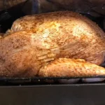 Roast Turkey being prepared for cooking in aluminum foil.