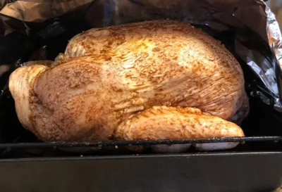 Roast Turkey being prepared for cooking in aluminum foil.