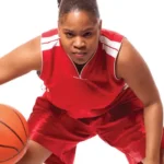 Female Basketball player prepares to take the ball down court.