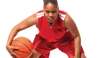 Female Basketball player prepares to take the ball down court.