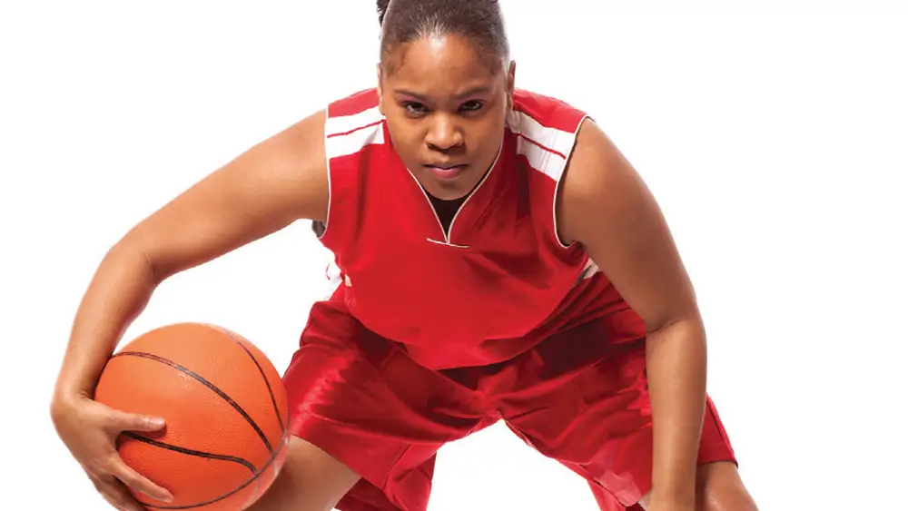 Female Basketball player prepares to take the ball down court.