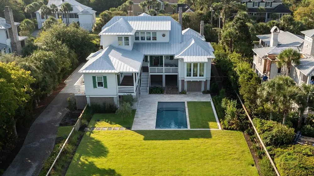 Aerial view of a Mount Pleasant home with custom pool landscaping, stone pavers, and a manicured lawn by GrandScapes.